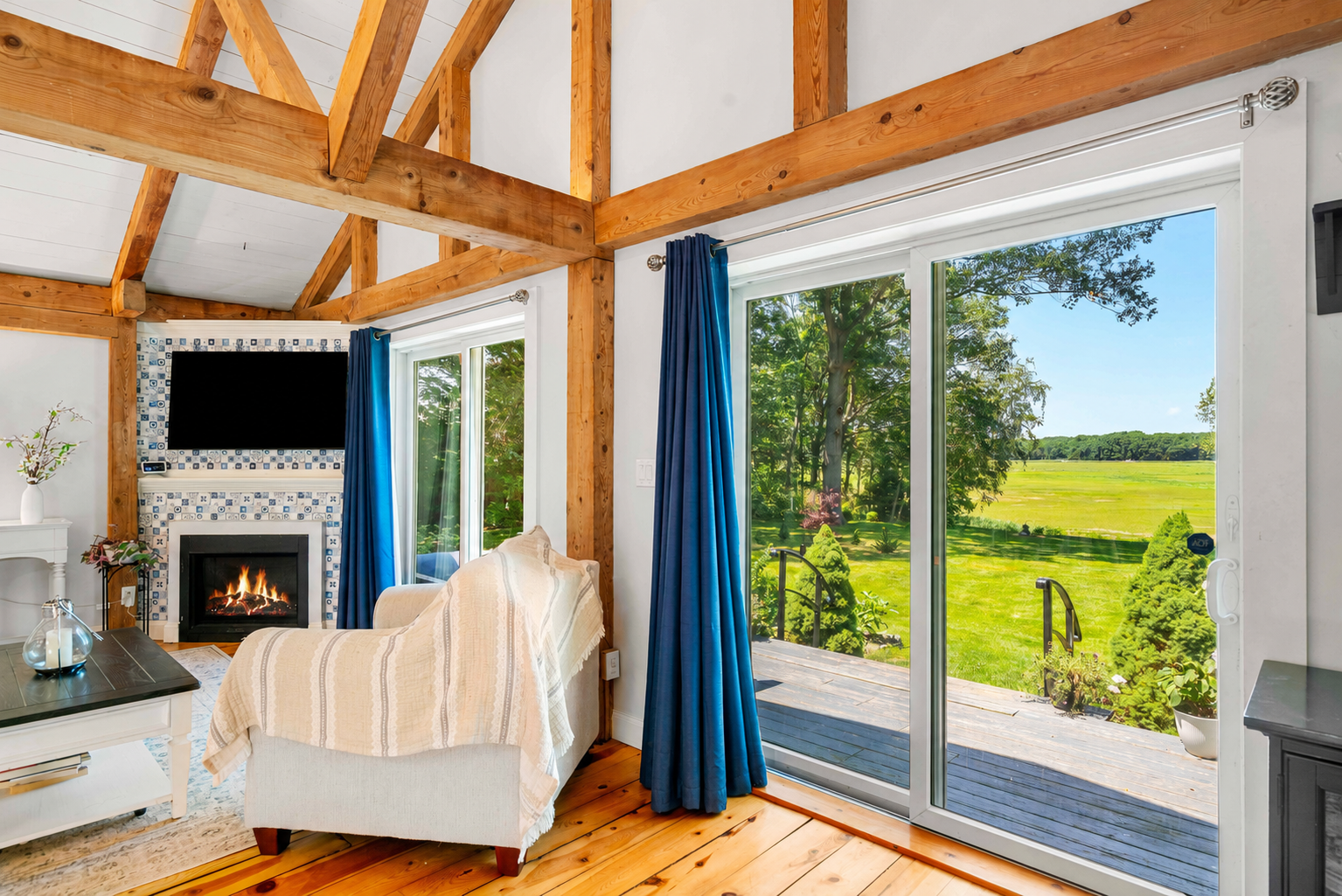 Tiled fireplace and sliders opening to the marsh view deck