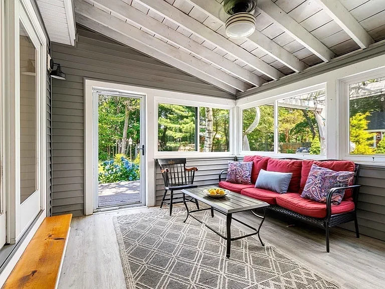 Screened sunroom with vaulted beadboard ceiling and garden views